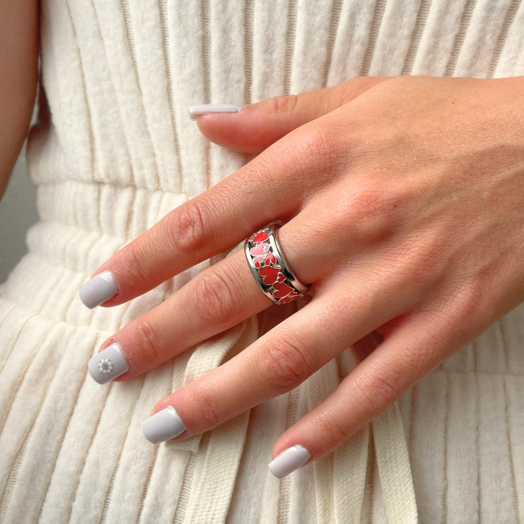 bague mood en argent avec des coeurs rouges portée par une femme habit blanc