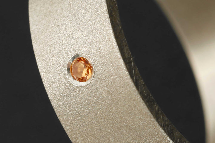 Setting of an orange Sapphire